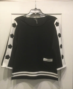 Black Round Neck Knit Top, 3/4 Sleeves and White Trim on Neck and Sides. Panels have Black Daisy Inserts by Orly.